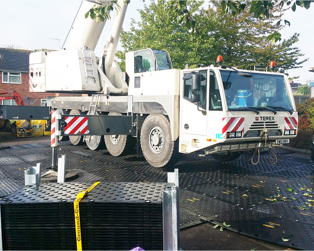 Terex crane on a construction site with trees and buildings in the background