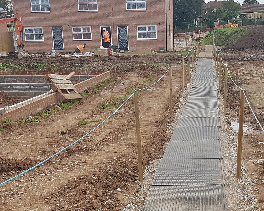 Construction site with a pathway and partially built houses