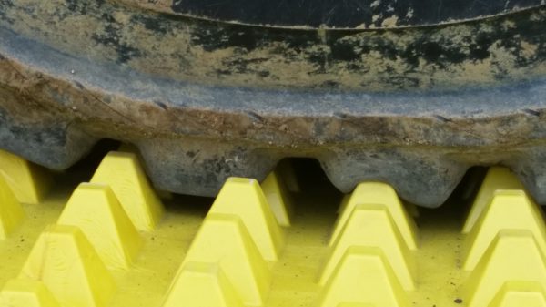 Scraping mud off construction vehicle tyre wheels